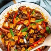 A plate of red tofu and mushroom curry.