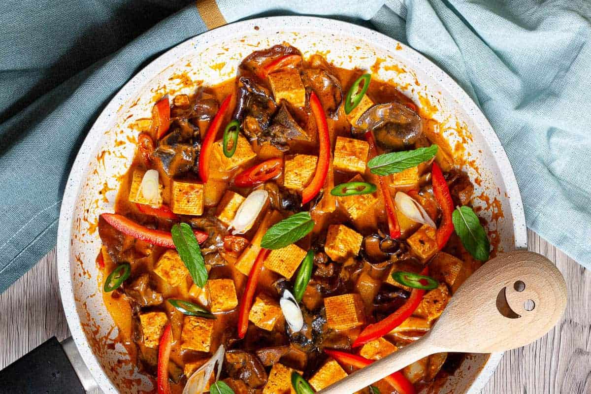 A plate of red tofu and mushroom curry.