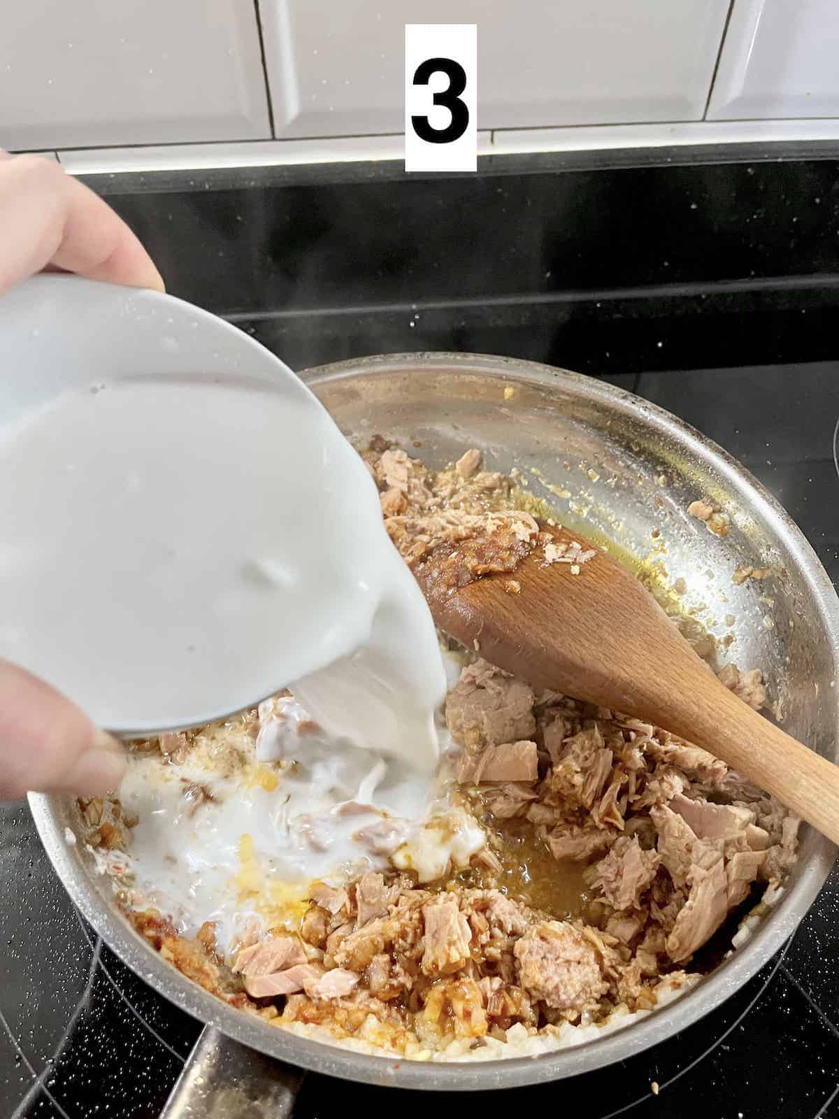 Pouring a bowl of coconut milk into the coconut sambal curry.