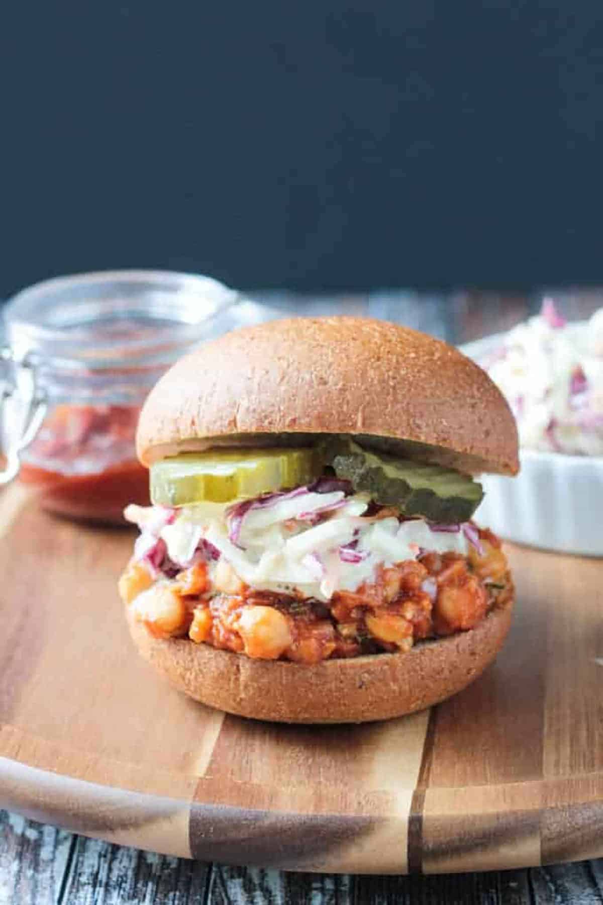 A chickpea slider with barbercue sauce on a wooden board