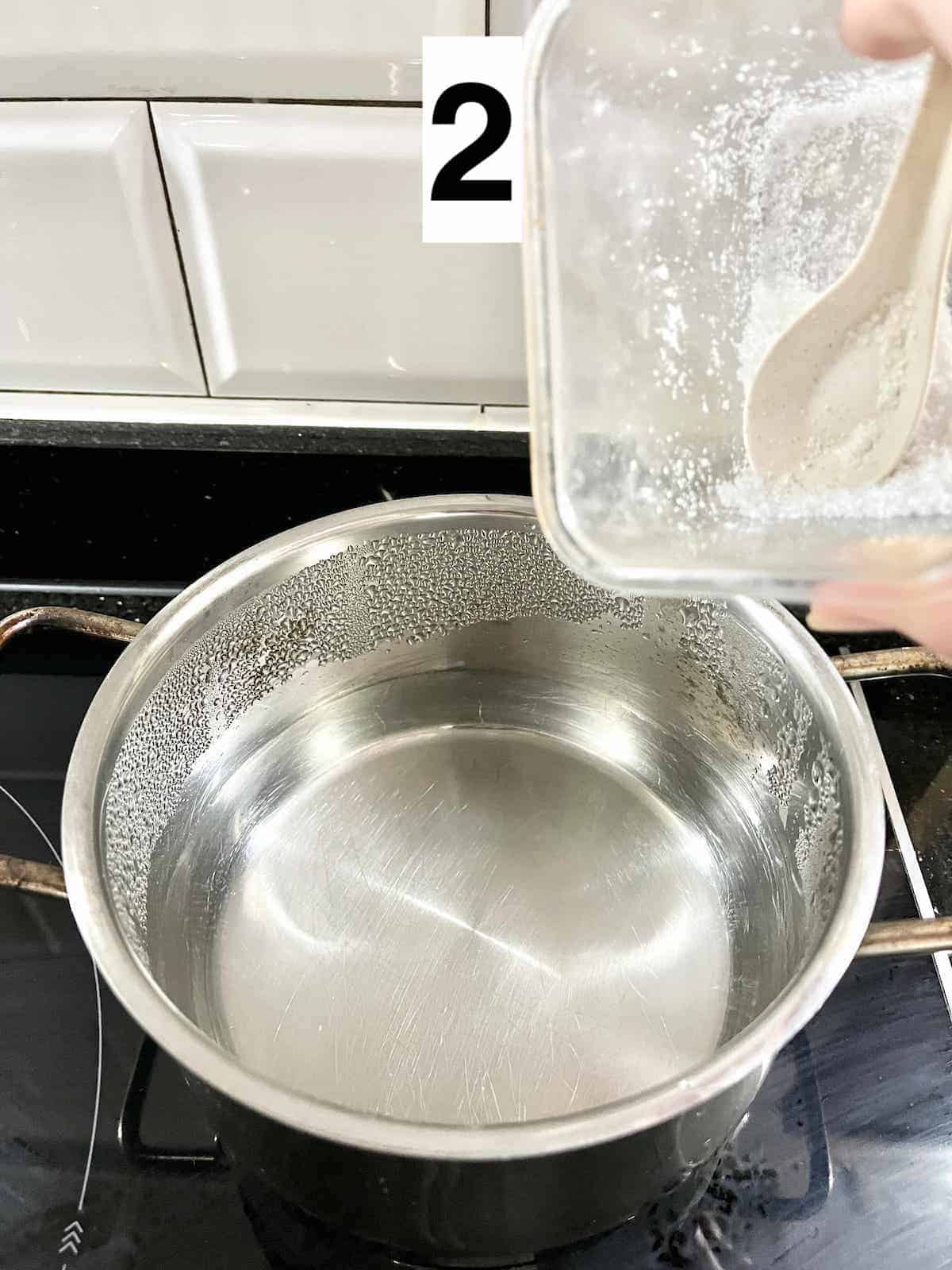 Adding salt to a pot of water.