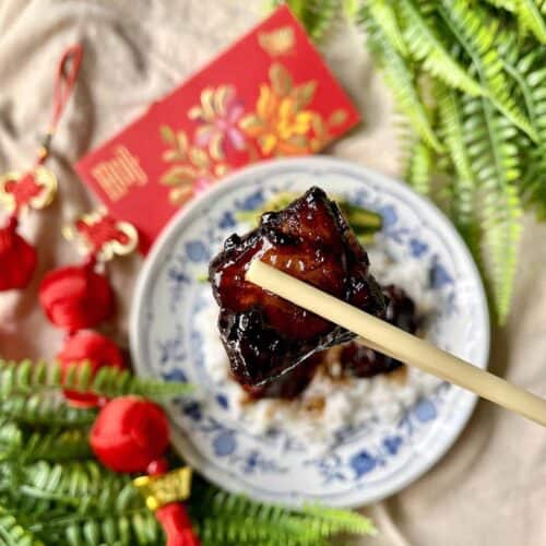 Close-up of a pork rib with fingerlicking sticky sauce and caramelised bits.