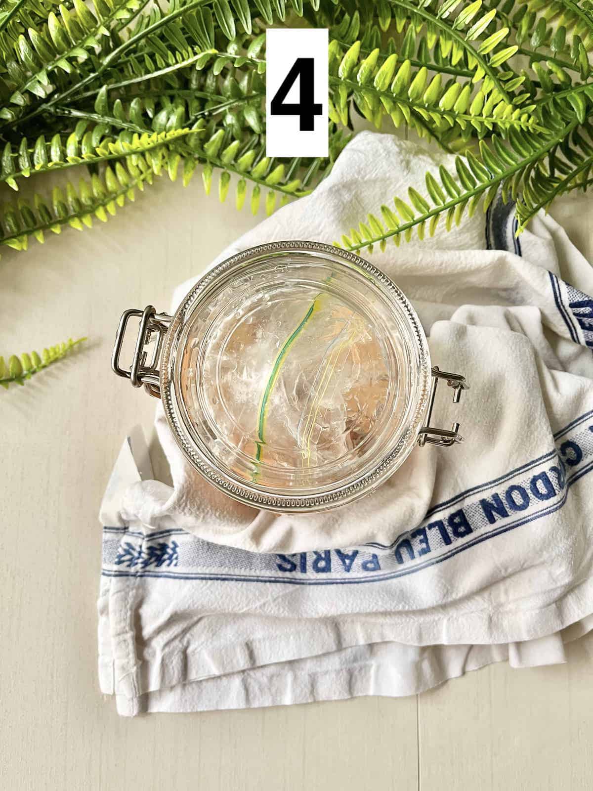 Overhead shot of a glass jar full of eggs and salt water.