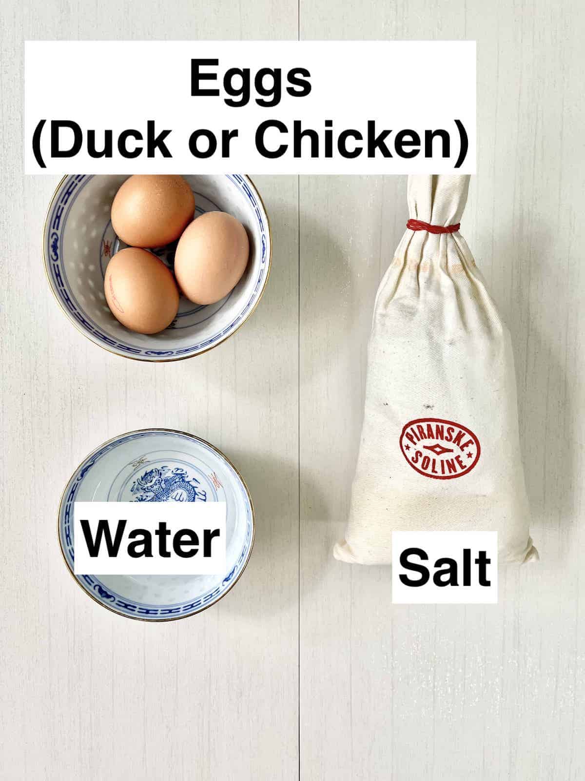A bowl of chicken eggs, a bowl of water and salt.