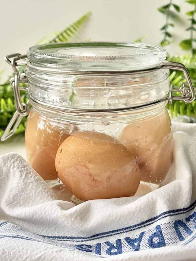 Chicken eggs in a glass jar full of salted brine solution.