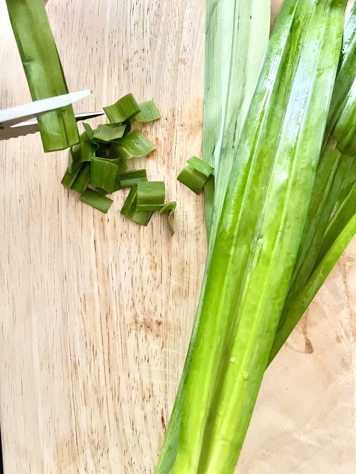 Cutting bruised pandan leaves into small pieces.