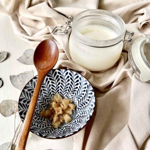 A jar of snow white homemade lard and a bowl of cracklings.