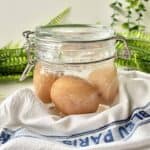 Chicken eggs in a glass jar full of salted brine solution.