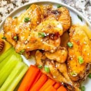 A plate of veggie crudités and honey wings.