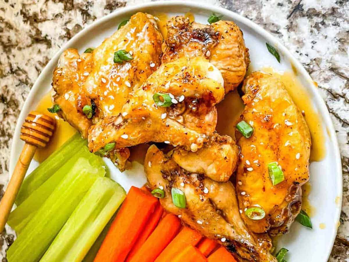 A plate of veggie crudités and honey wings.