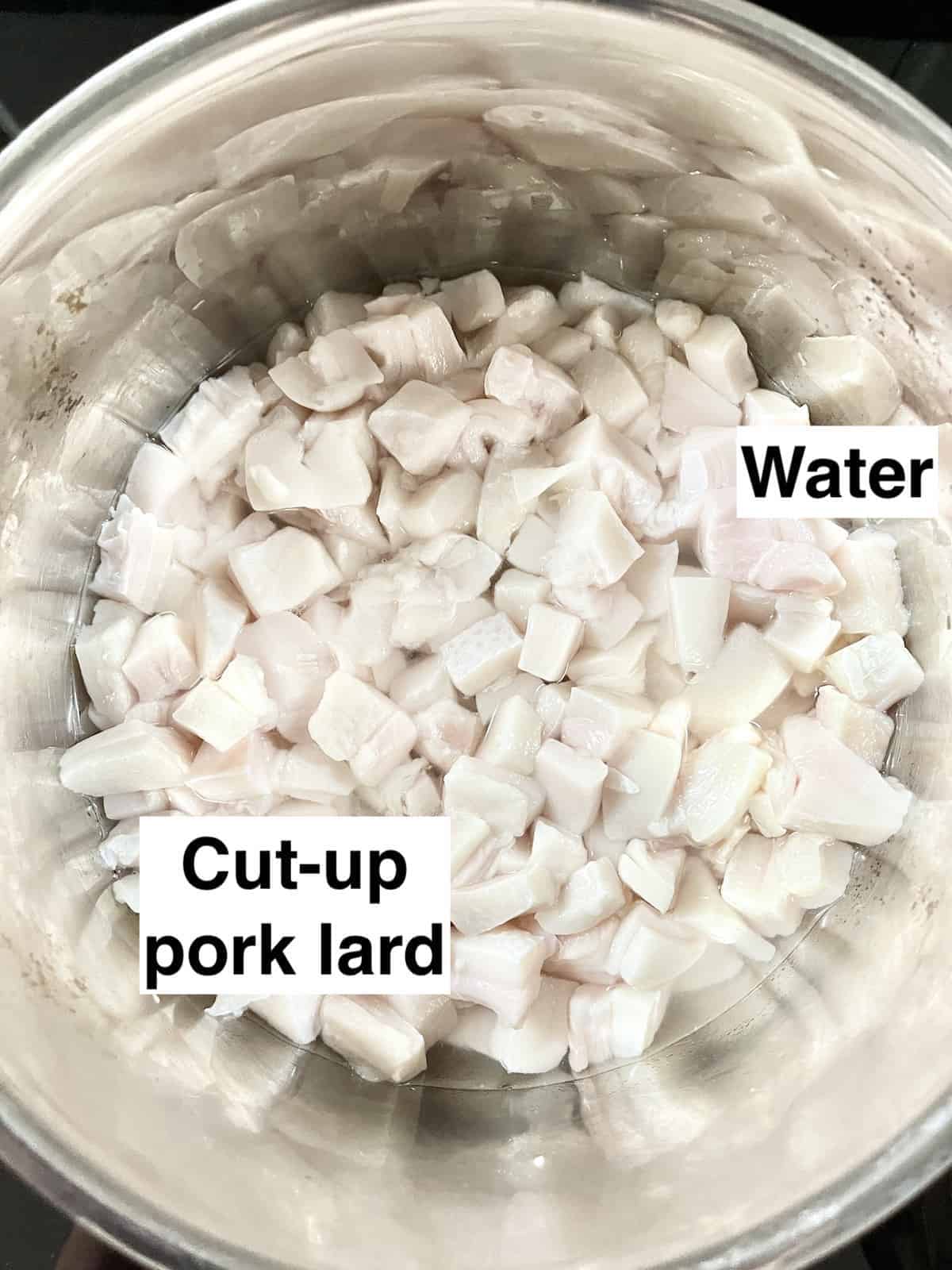 A pot of pork lard cut into small pieces and a bit of water.
