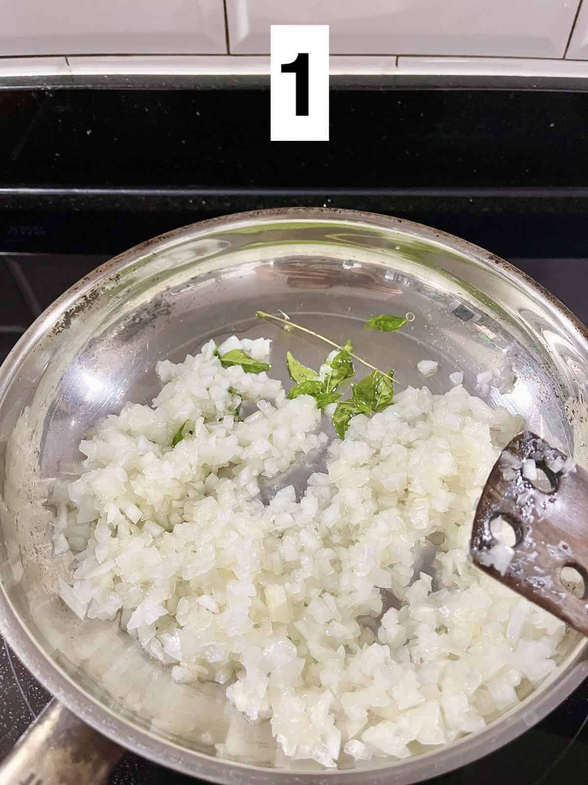 Sauteeing minced onions and curry leaves.