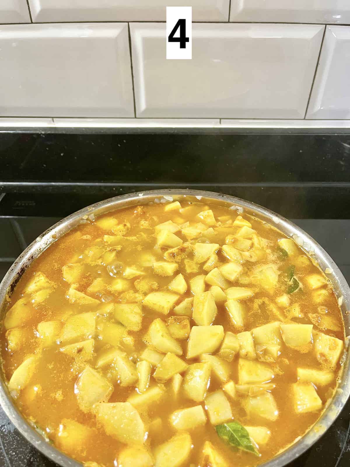 Simmering potatoes in curry.