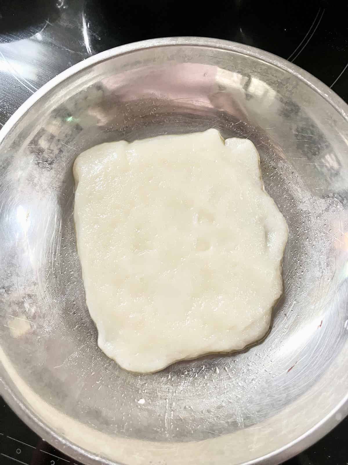 A piece of translucent, cooked glutinous rice dough.