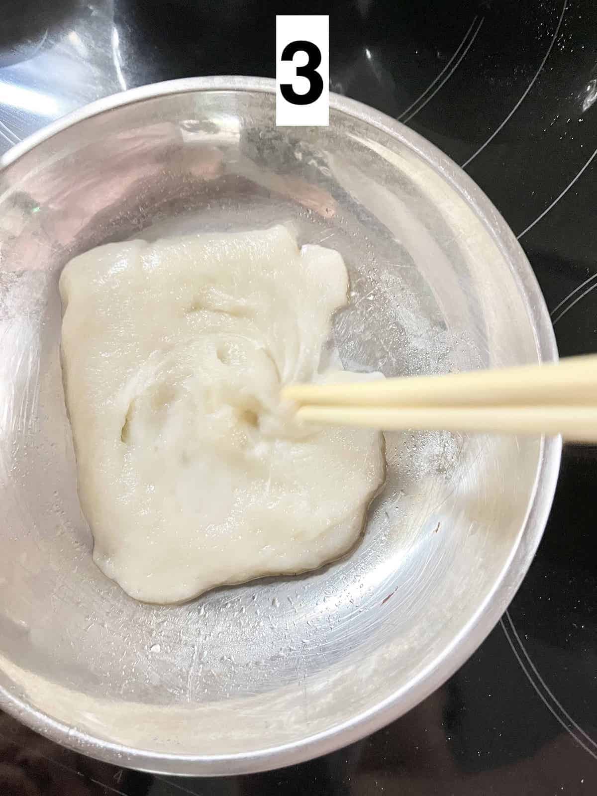 Using chopsticks to stir sticky glutinous rice flour dough.