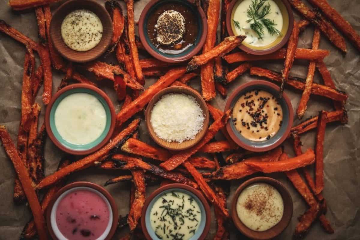 9 different aioli dips surrounded by sweet potato fries