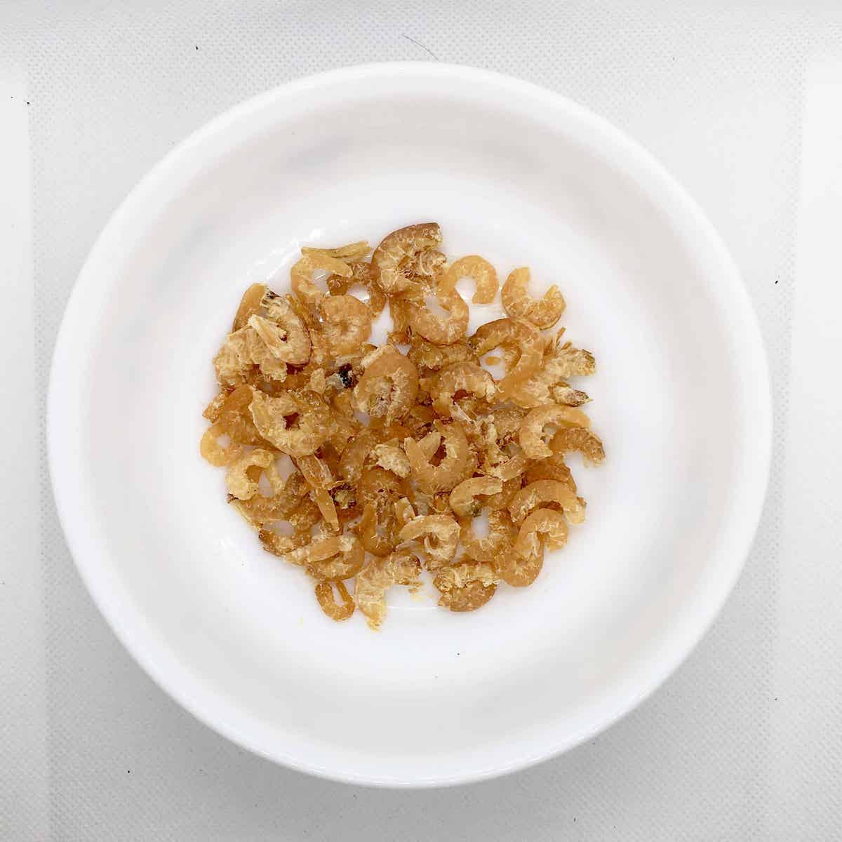 Asian dried shrimps in a white bowl.