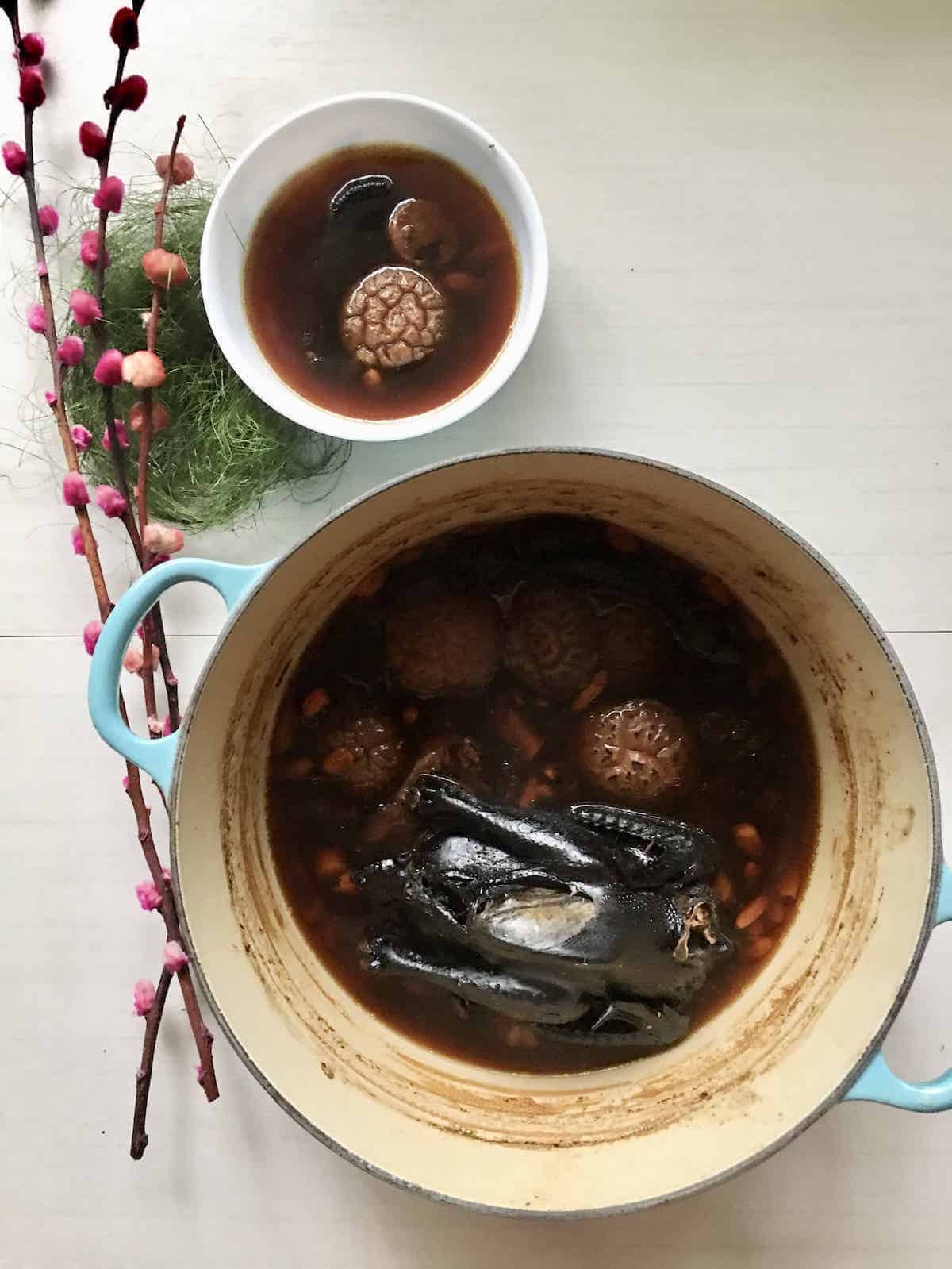 A pot of Asian silkie chicken non-herbal soup in a Dutch oven.