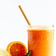 A glass of orange coloured goji berry smoothie.