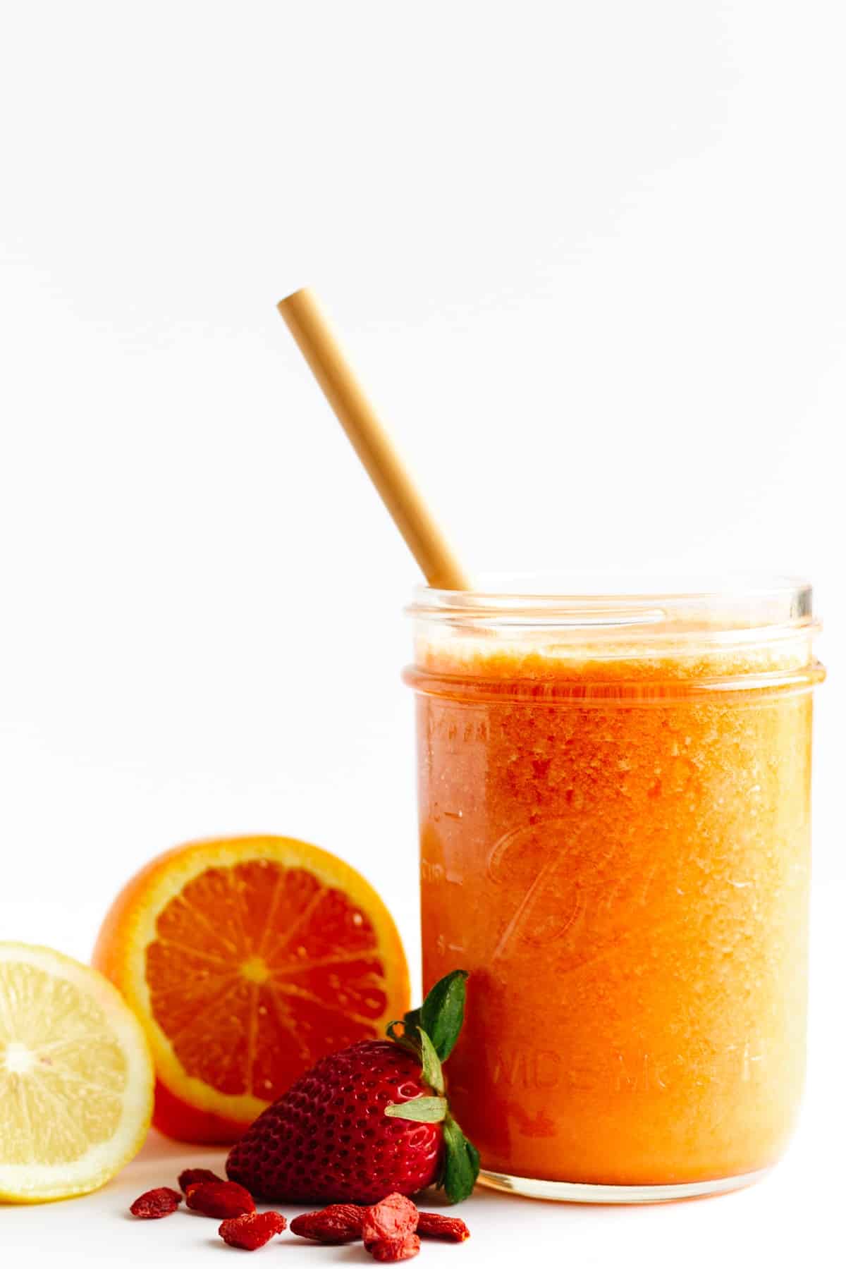 A glass of orange coloured goji berry smoothie.