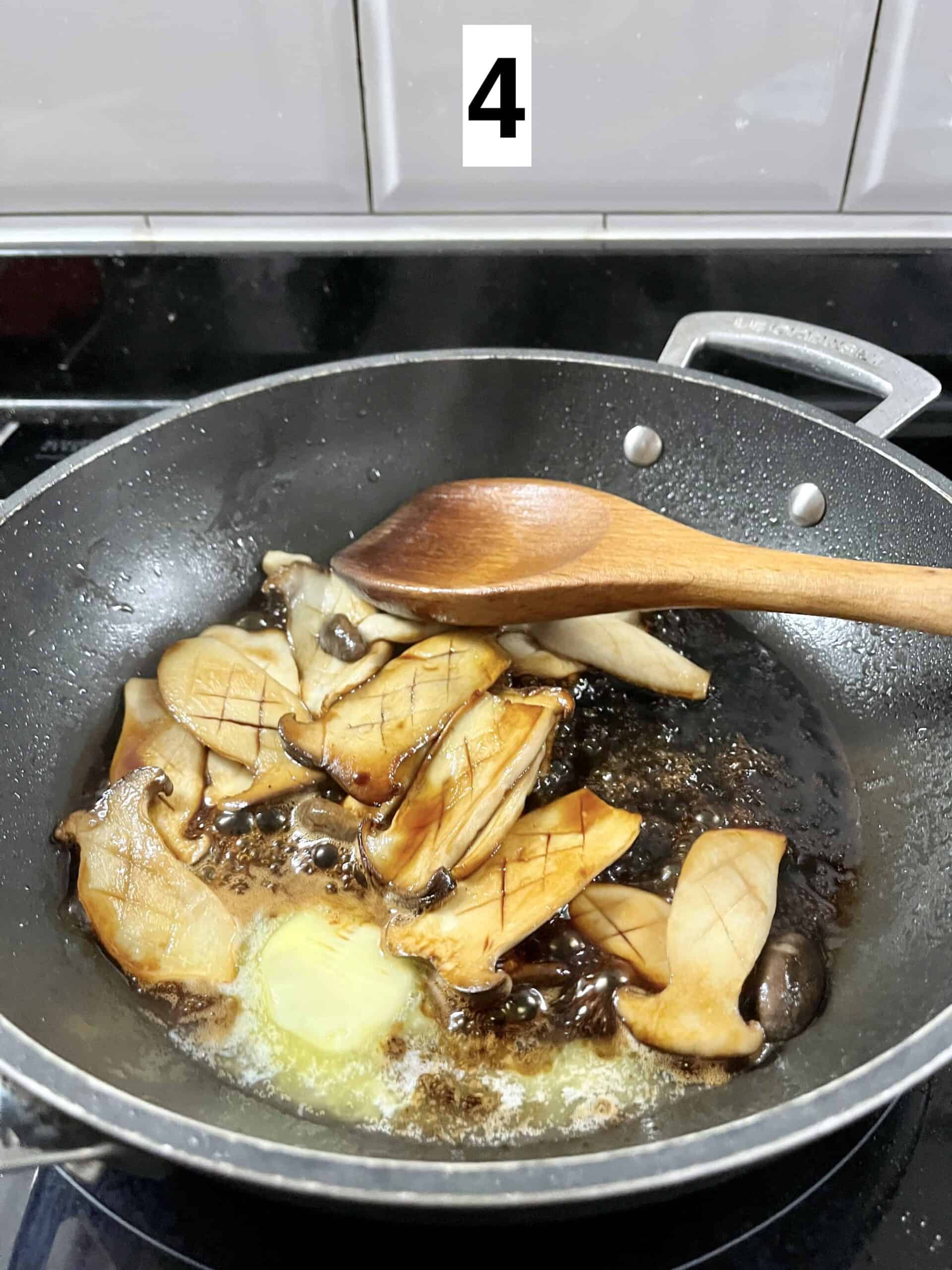 Melting butter and soy sauce with mushrooms in a pan.
