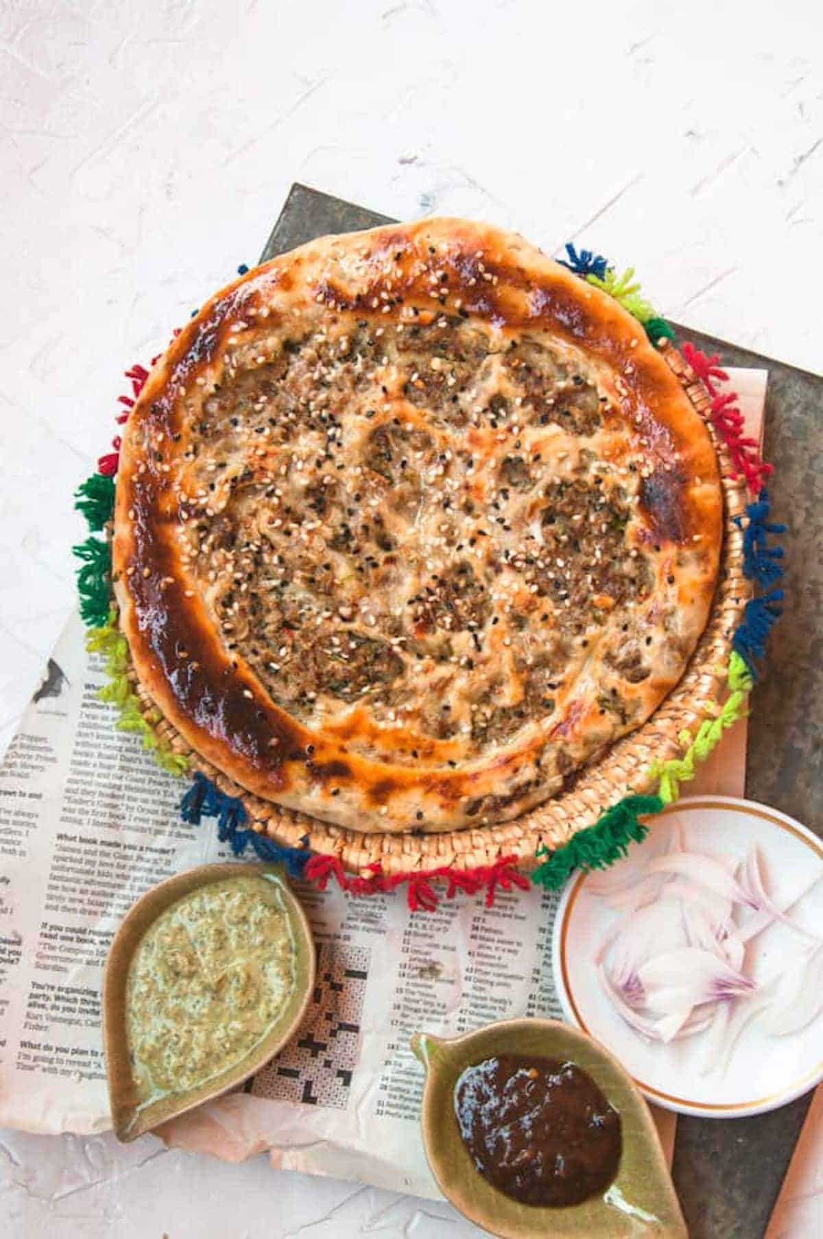 Indian keema naan flatbread with a dip on the side.