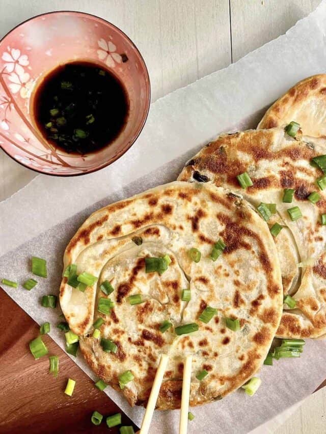 Crispy and flaky pan fried scallion pancakes on parchment paper.