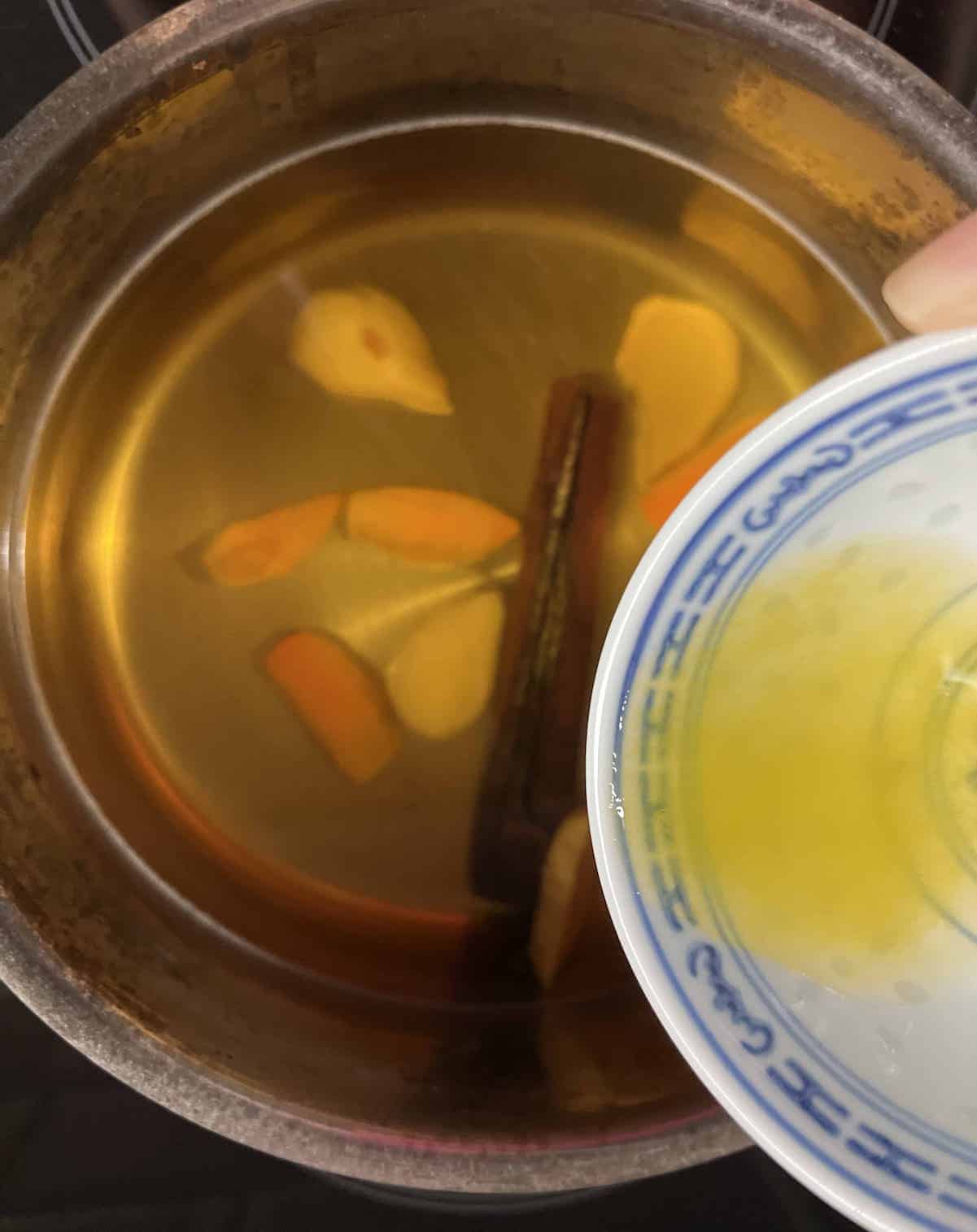 Adding lemon juice to the pot of ginger turmeric and cinnamon tea.