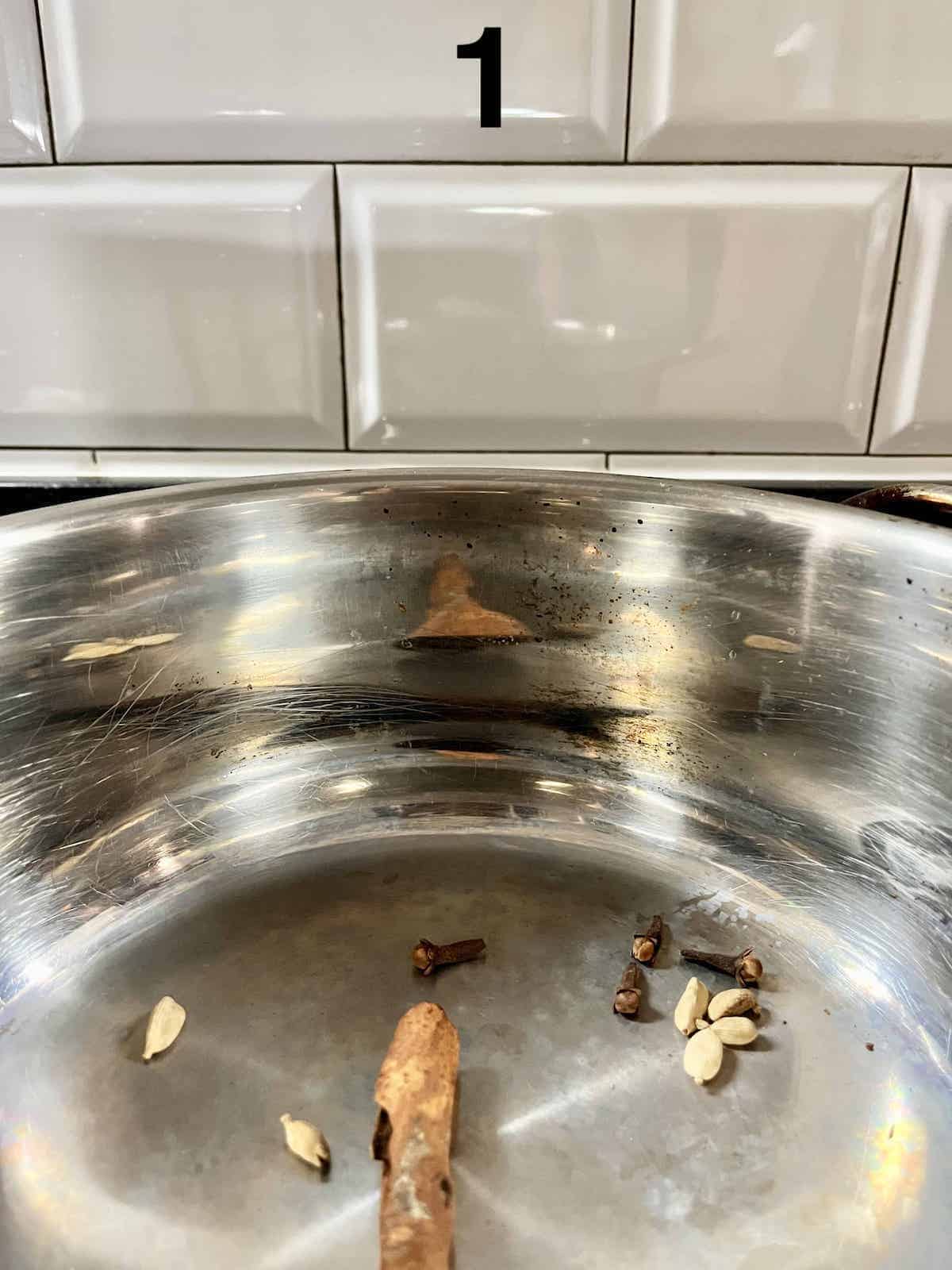 Dry toasting cardamom, cinnamon and cloves in a pan.