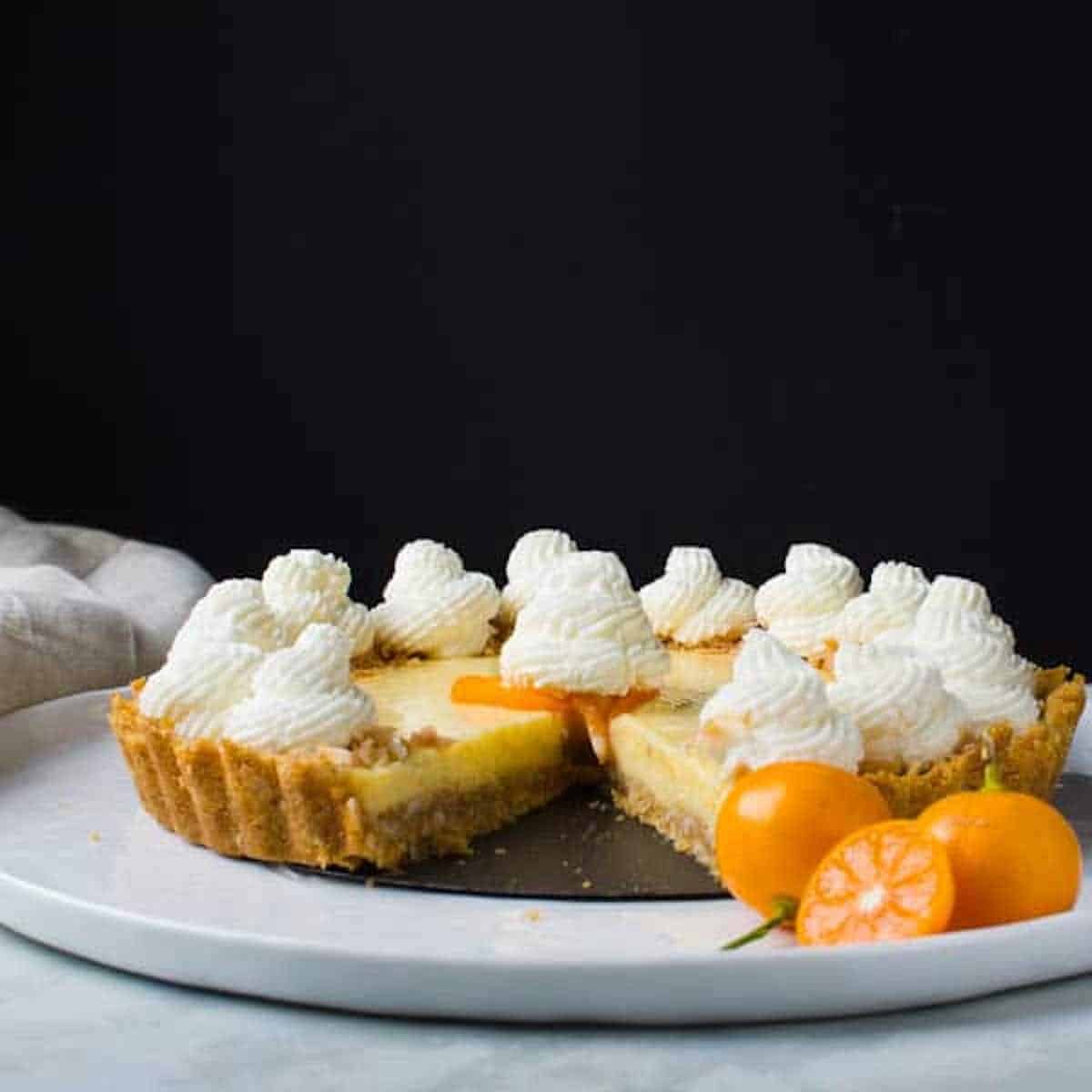 Side view of a calamansi pie tart with white topping.