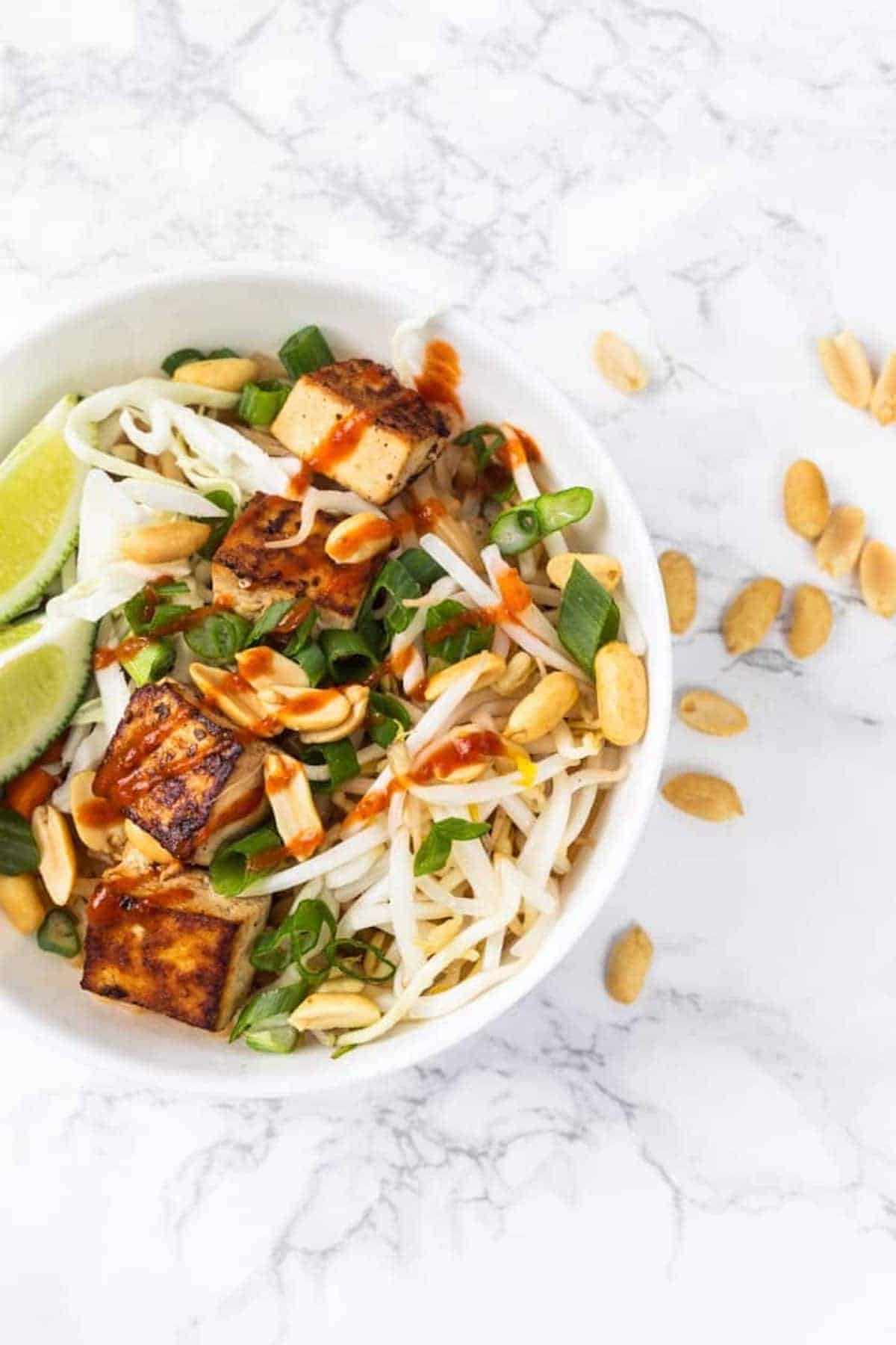 Bowl of vegan pad Thai noodles with tamarind sauce.