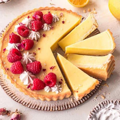 Vegan lemon tart made with turmeric and topped with raspberries.