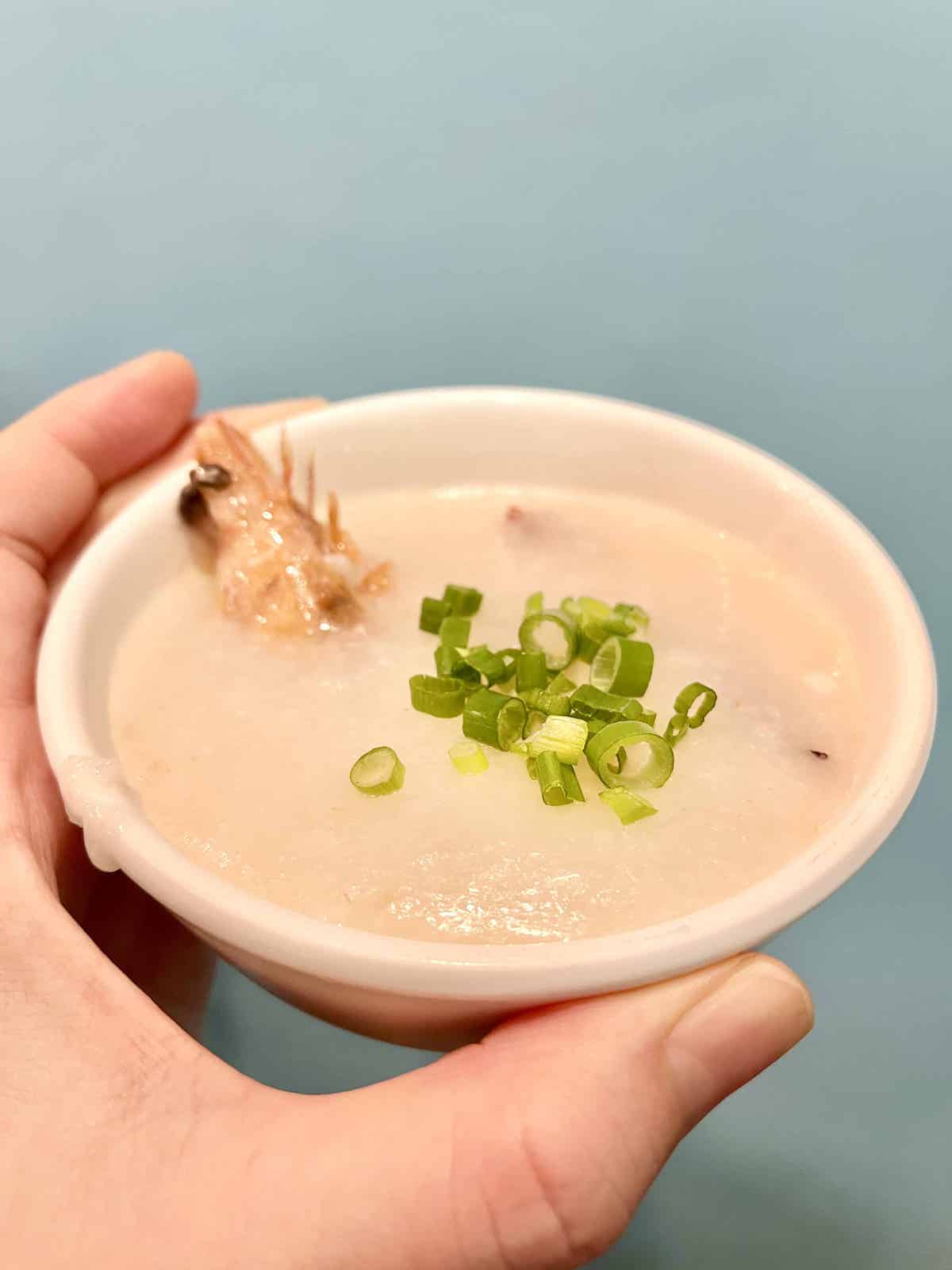 A bowl of shrimp congee toped with fresh green onions.