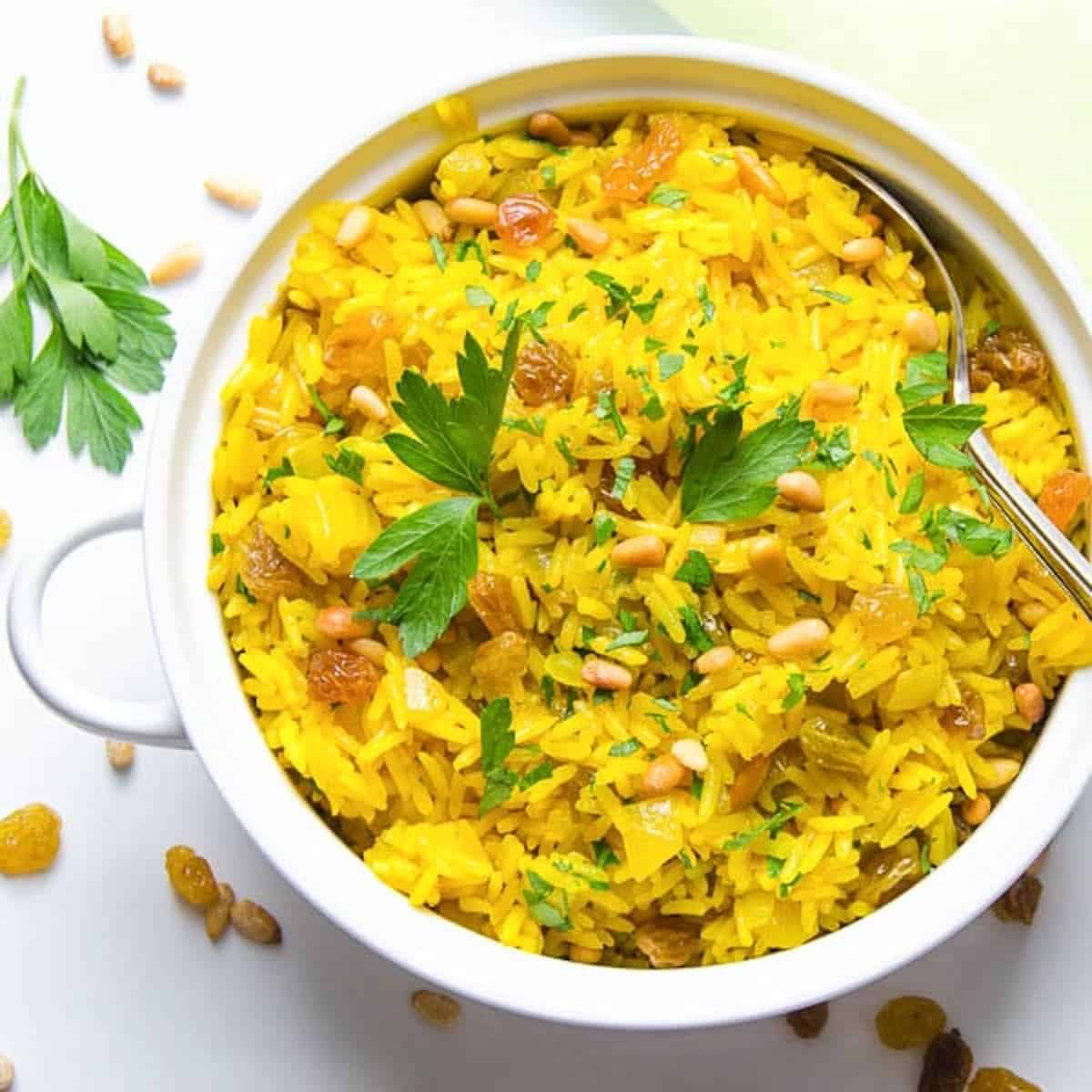 Yellow turmeric pilaf in a white bowl.