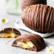 Vegan creme egg for Easter cut in half so you can see the filling inside.