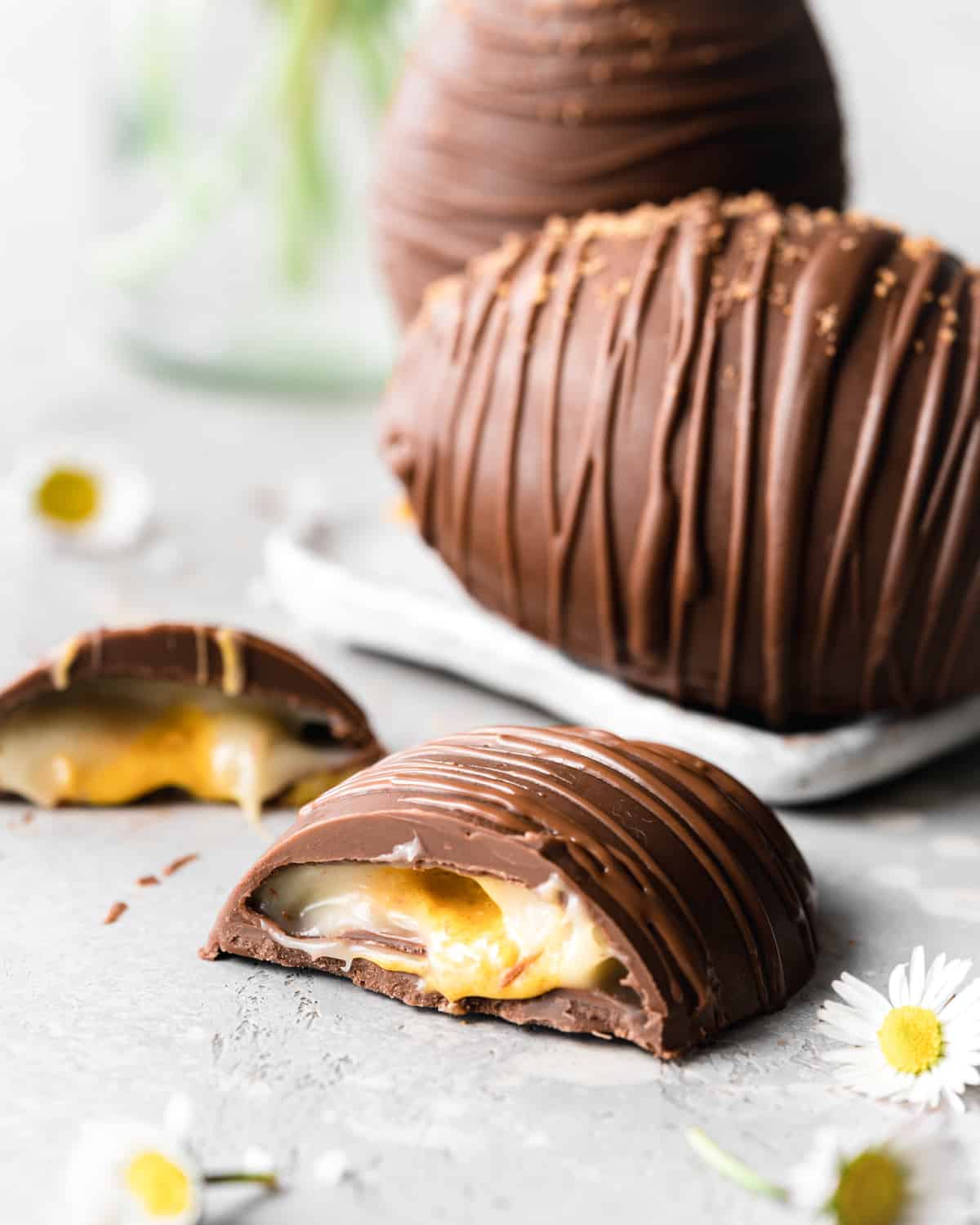 Vegan creme egg for Easter cut in half so you can see the filling inside.