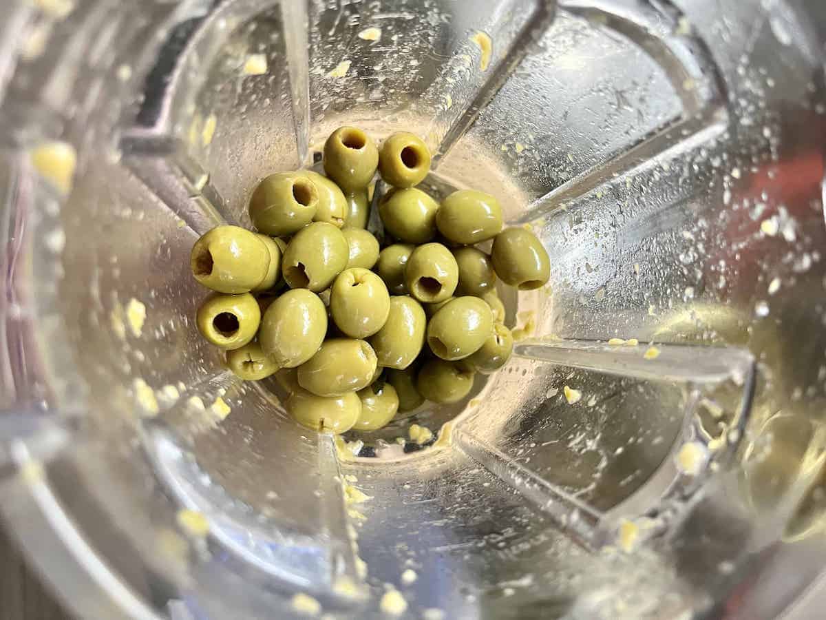 Green olives in a food blender.