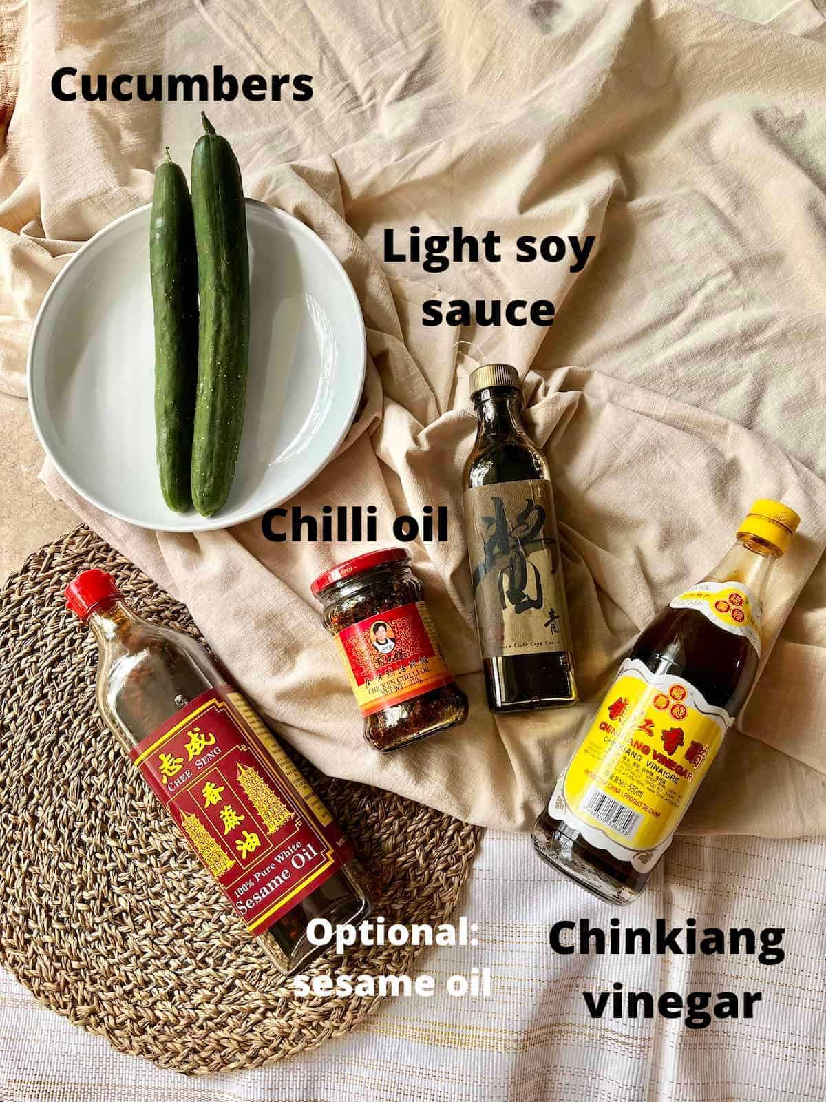 The ingredients needed for Chinese cold cucumber salad laid flat on a tablecloth. 