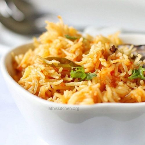 Close-up of South Asian tomato rice in a white bowl.