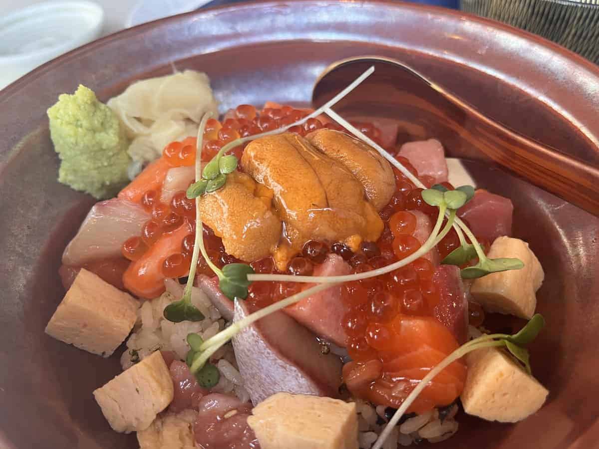 A bowl of Japanese bara chirashi with cubed fish, eggs and uni.