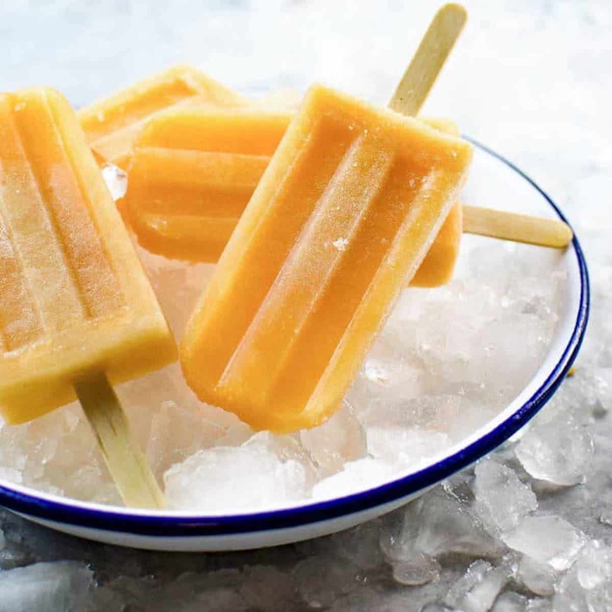 3 lychee fruit popsicles on a bowl of ice.