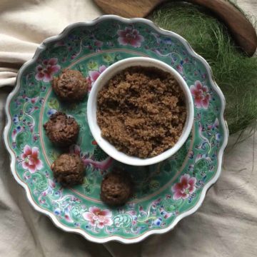 Bowl of homemade light brown sugar next to a plate of chocolate chip cookies