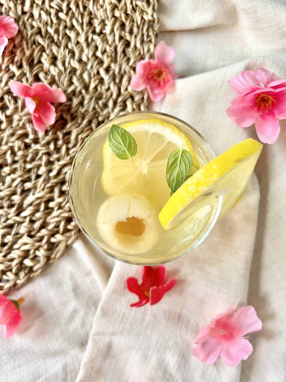 Overhead shot of a glass of cold lemon lychee tea with mint.