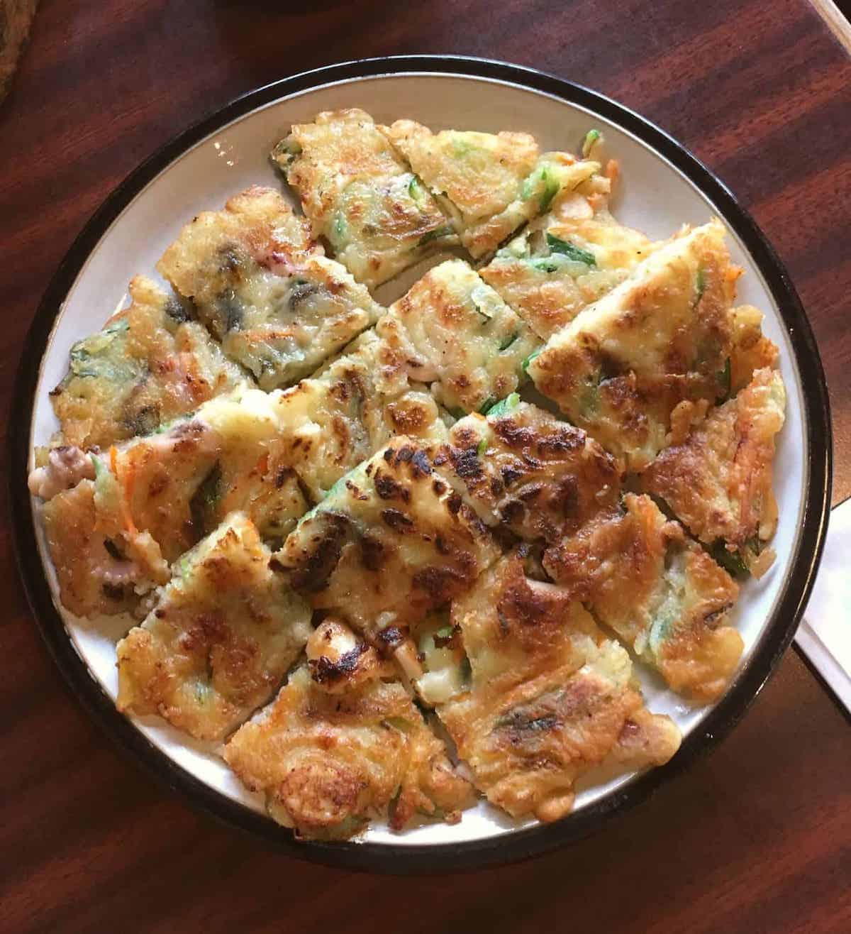 Close up of a pan-fried Korean savoury pancake with seafood.