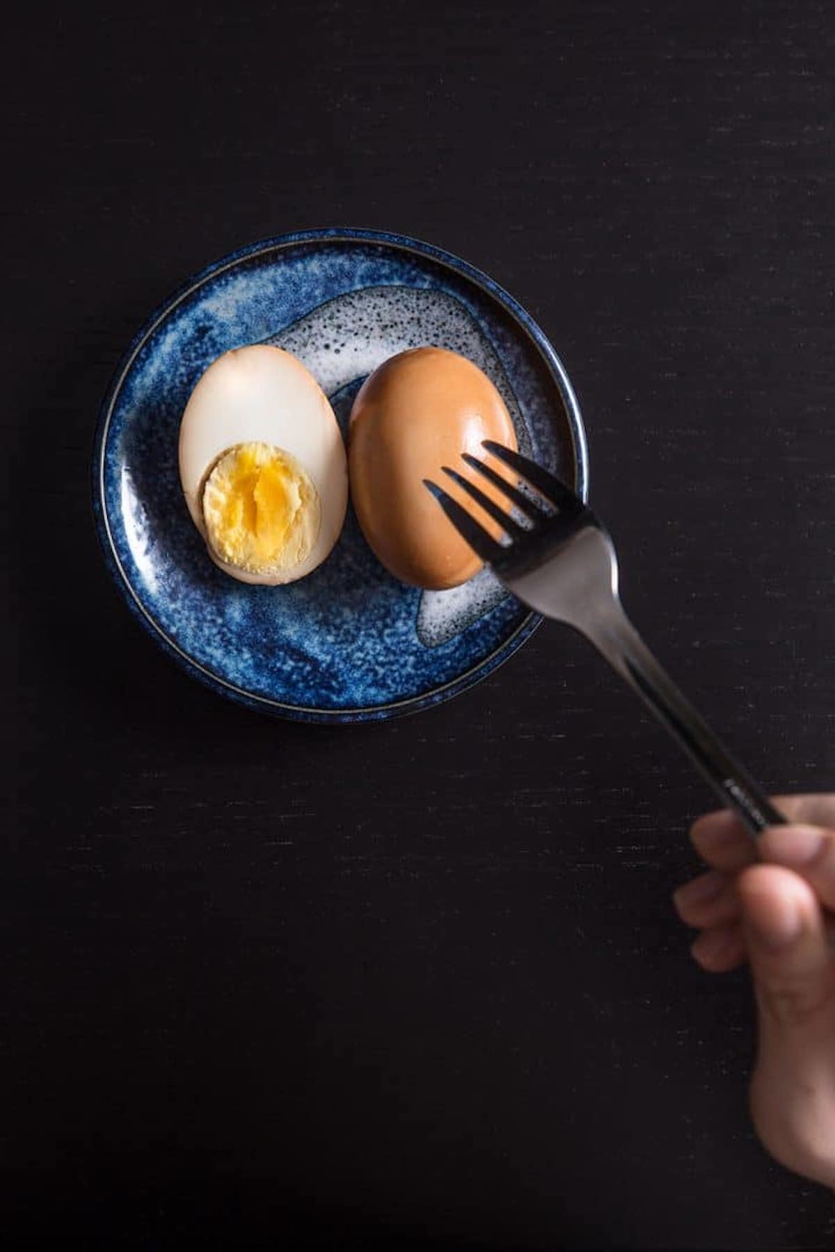 A photo of 1 whole and 1-halved braised egg.