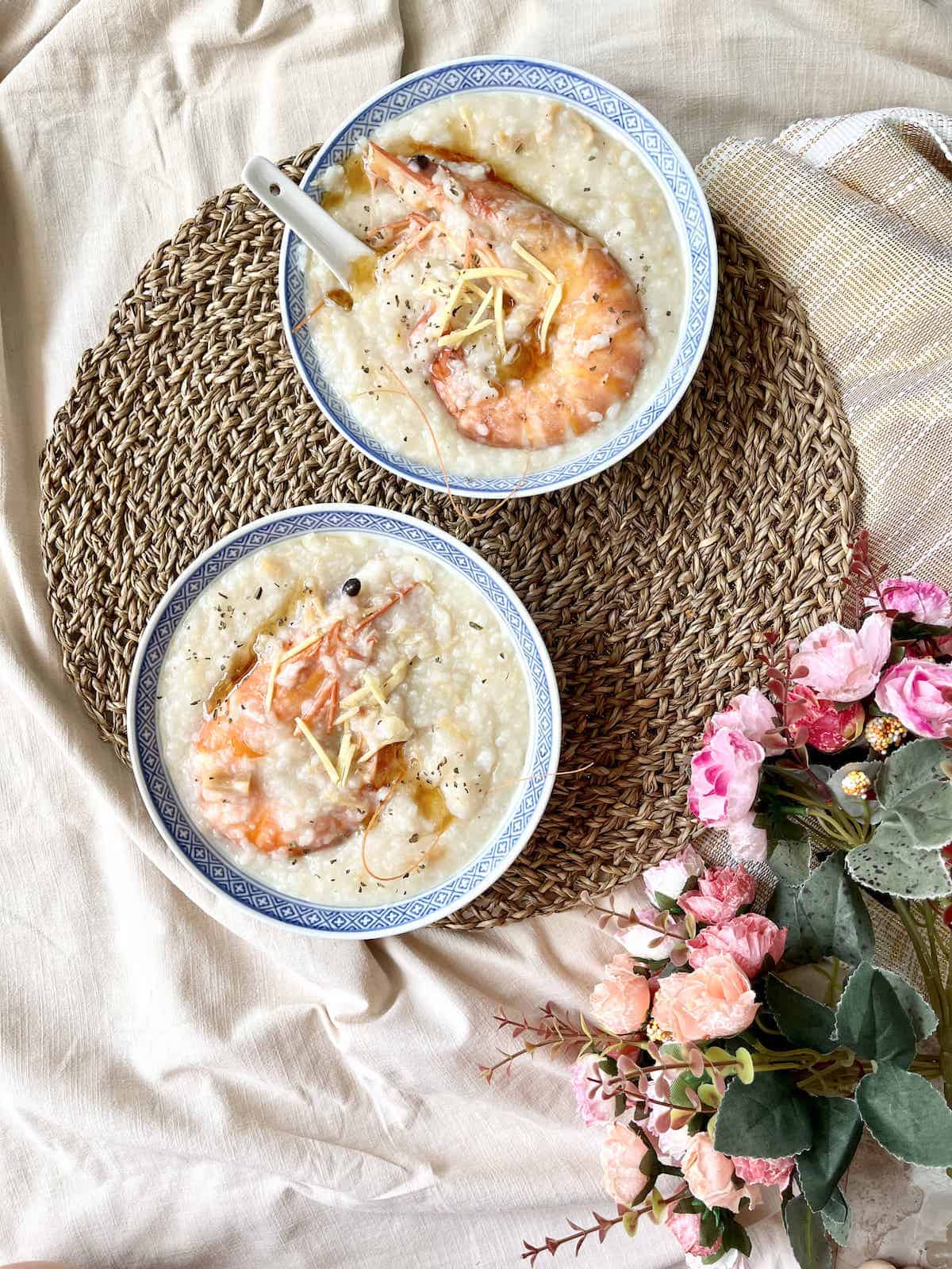 2 bowls of mixed seafood congee with prawns and conpoy.