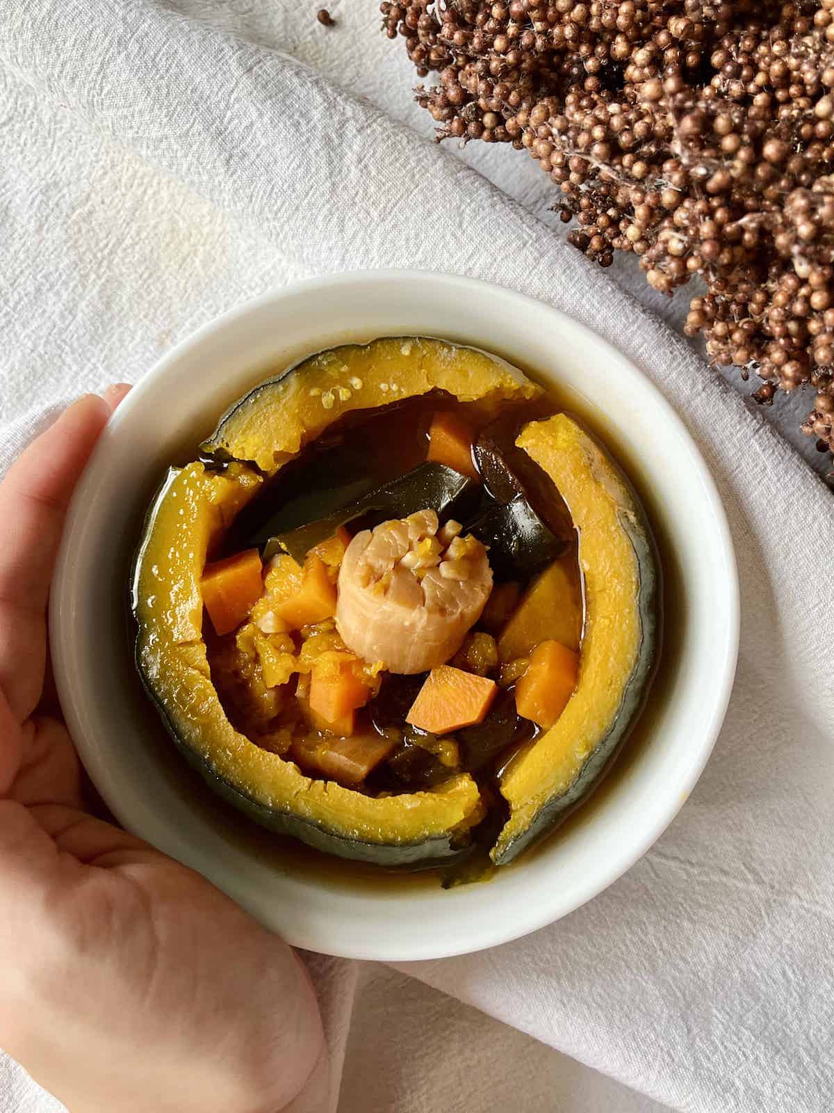 Close-up of a bowl of Chinese steamed soup in a pumpkin bowl.