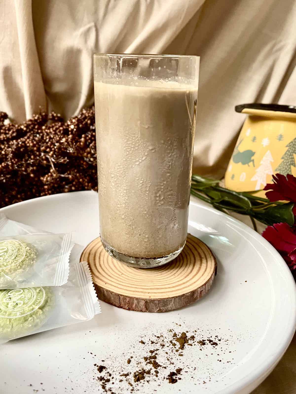 A glass of cold Hojicha latte on a white plate.