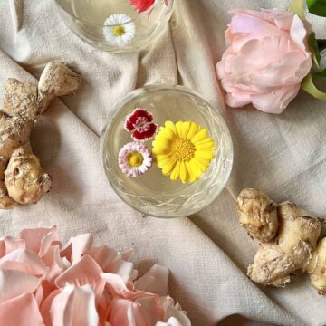 Overhead shot of lemongrass tea with edible flowers floating in it.