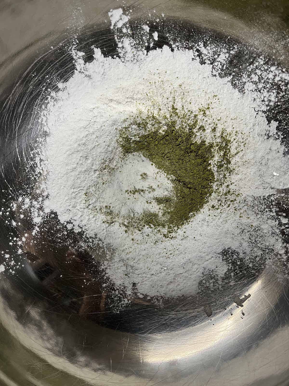 All the dry ingredients for the matcha mochi muffins in a stainless steel bowl.